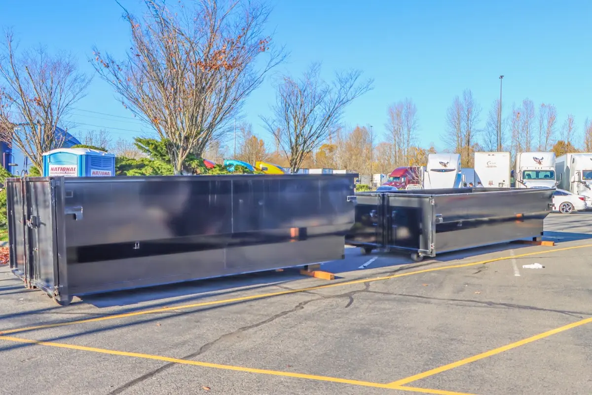 Professional dumpster rental service with roll-off container on residential driveway in East Orange